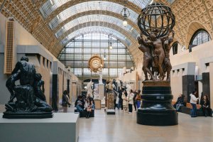 Wide interior of Musée d’Orsay main hall with sculptures beneath glass ceiling